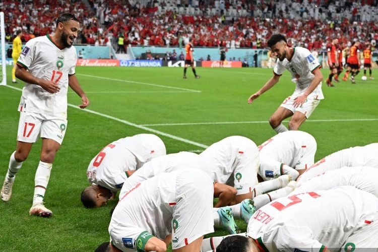 Pemain-pemain Maroko melakukan sujud syukur usai Abdelhamed Sabiri menjebol gawang Belgia dalam laga Grup F Piala Dunia 2022 Belgia vs Maroko di Stadion Al-Thumama, Doha, 27 November 2022. (Photo by MANAN VATSYAYANA / AFP)