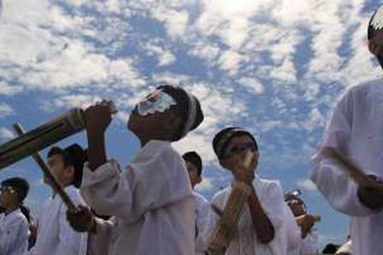 Anak-anak di Kota Ternate, Maluku Utara, memainkan alat musik dolo-dolo saat gerhana matahari total melewati daerah itu, Rabu (9/3/2016). Dalam suasana kegembiraan dan penuh rasa syukur, puluhan ribu orang, termasuk 1.157 wisatawan asing, menyaksikan fenomena alam nan langka dari kota itu.