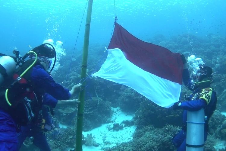 Sejumlah komunitas penyelam yang berada di Kabupaten Wakatobi, Sulawesi Tenggara, melaksanakan upacara bendera di bawah laut di pantai Cemara Waha Wakatobi, Selasa (17/8/2021).