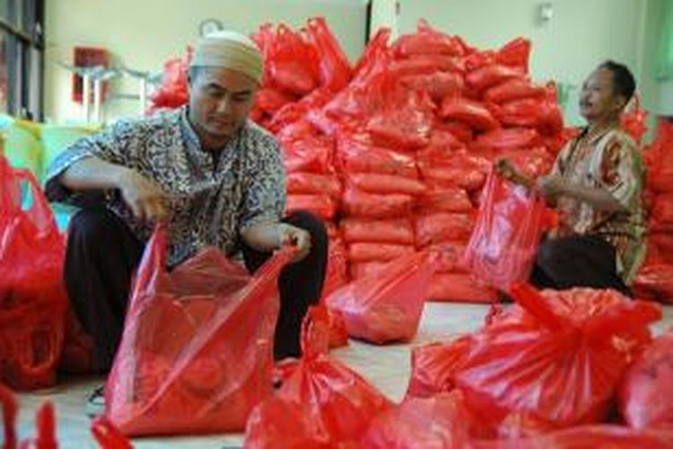 Petugas mengemas paket zakat untuk dibagikan di Kantor Pusat Perum Pegadaian, Jalan Kramat Raya, Jakarta Pusat, Jumat (3/9/2010). Pegadaian menyediakan 1.400 paket zakat berisi lima kilogram beras dan uang Rp 100.000 untuk diberikan kepada warga miskin.  