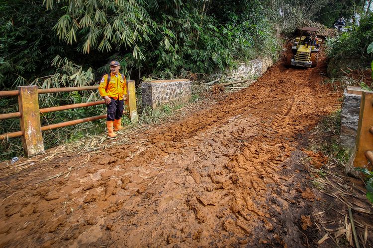 Petugas BPBD Bandung Barat tengah melakukan evakuasi material longsor yang menutup jalan penghubung dua kecamatan di Cikalongwetan, Bamdung Barat, Minggu (4/9/2022).