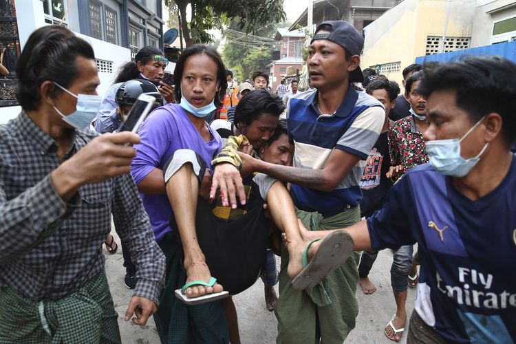 Seorang pria digotong setelah terkena tembakan polisi di Mandalay, Myanmar, pada Sabtu (20/2/2021). Polisi mulai menggunakan peluru karet dan peluru tajam untuk membubarkan massa anti-kudeta
