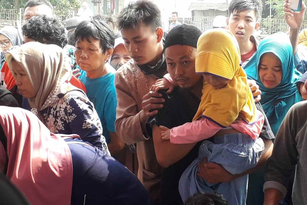 Kayla, anak sulung Fatmawati digendong oleh ayahnya saat pemakaman ibunya di Tangerang pada Jumat (2/8/2019)