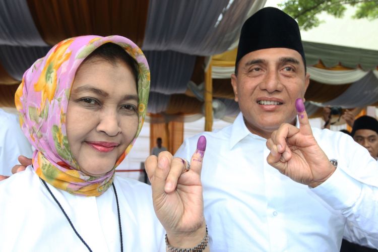 Calon Gubernur Sumatera Utara nomor urut satu Edy Rahmayadi (kanan) didampingi istri Nawal Lubis, menunjukkan jari kelingking usai memberikan hak suara pada Pilgub Sumut, di TPS 15, Lingkungan VII Pangkalan Masyhur, Medan Johor, Medan, Sumatera Utara, Rabu (27/6/2018). Pilgub Sumatera Utara diikuti dua pasangan calon, Edy Rahmayadi-Musa Rajekshah dan Djarot Saiful Hidayat-Sihar Sitorus dengan total DPT 9.050.483 jiwa.