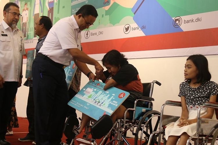 Terlihat salah satu peyandang disabilitas mencium tangan Gubernur DKI Jakarta Anies Baswedan karena mendapatkan Kartu Penyandang Disabilitas Jakarta (KPDJ).