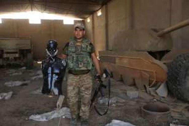 Seorang prajurit Irak memperlihatkan manekin dan tank kayu yang digunakan ISIS untuk mengelabui pasukan gabungan Irak yang menyerbu kota Mosul.