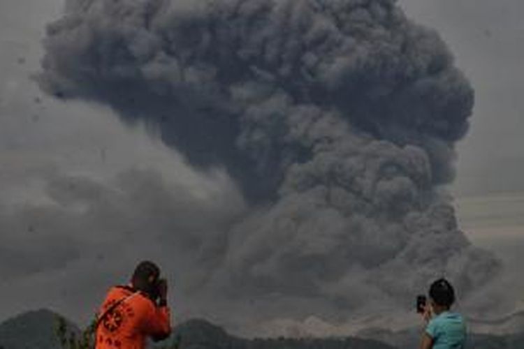 Warga dan tim SAR mengabadikan abu vulkanik yang membubung tinggi keluar dari Gunung Kelud yang terlihat dari jarak lima kilometer di Desa Penataran, Kecamatan Nglegok, Kabupaten Blitar, Jumat (14/2/2014). Menurut Pusat Vulkanologi dan Mitigasi Bencana Geologi (PVMBG), Gunung Kelud yang meletus pada Kamis (13/2/2014) pukul 22.50 WIB bersamaan keluarnya tremor tersebut, mengalami 442 kali gempa vulkanik dangkal (VB). 