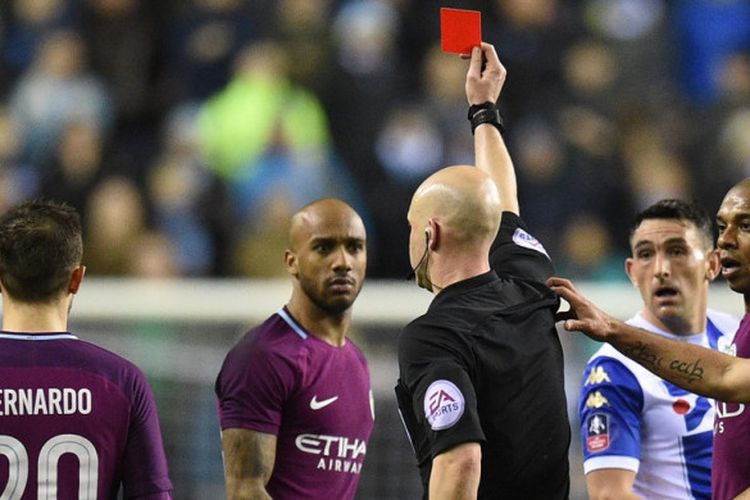 Wasit Anthony Taylor (tengah) memberikan kartu merah untuk bek kiri Manchester City, Fabian Delph, dalam laga babak kelima Piala FA kontra Wigan Athletic di Stadion DW, Wigan, Inggris, pada 19 Februari 2018.
