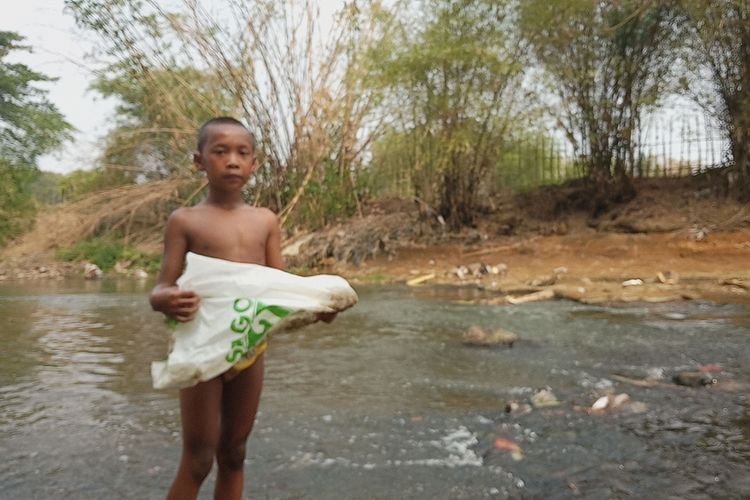 Sejumlah anak-anak berenang dan menemukan sampah plastik di bantaran Sungai Ciliwung yang tercemar gunung sampah yang ada di Kampung Kedunghalang Lebak, Desa Cilebut Timur, Kecamatan Sukaraja, Bogor, Jawa Barat, Rabu (25/9/2019).