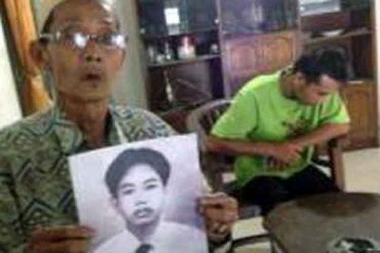 Sadiq memperlihatkan foto Effendi, anaknya yang terancam hukuman gantung di Malaysia, Jumat (4/4/2014). 
