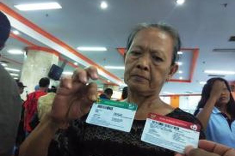 Seorang warga menerima Kartu Indonesia Sehat (KIS) yang diluncurkan oleh Presiden Joko Widodo di Kantor Pos Jakarta Pusat, Senin (3/11/2014).