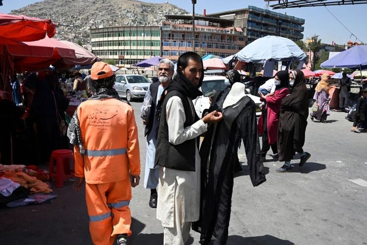 Orang-orang berjalan di sepanjang pasar di pusat kota Kabul pada 28 Agustus 2021, setelah militer Taliban mengambil alih Afghanistan. [AFP/Aamir Qureshi]