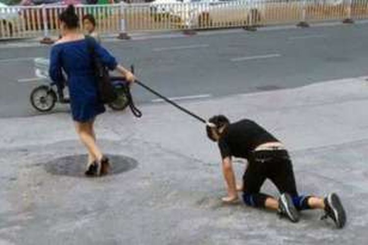 Perempuan ini seret kekasihnya menggunakan tali anjing di jalanan kota Fuzhou, China dalam sebuah aksi aneh yang menarik perhatian warga.