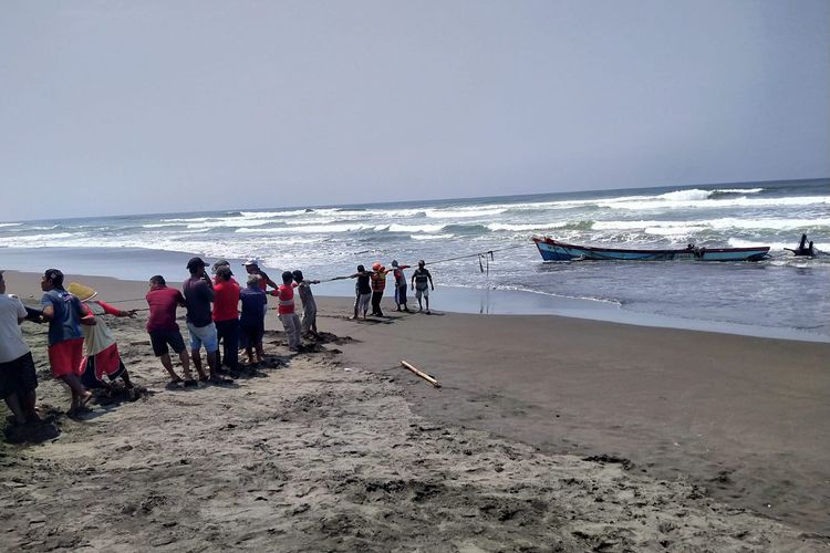 Warga mengevakuasi perahu Tri Laksana yang terbalik di Pantai Wagir Indah, Desa Welahan Wetan, Kecamatan Adipala, Kabupaten Cilacap, Jawa Tengah, pada Rabu (18/10/2023).