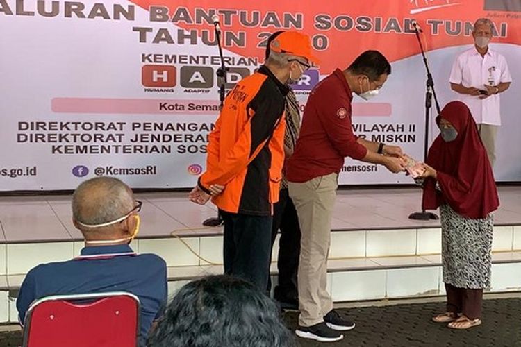 Menteri Sosial Juliari P. Batubara, saat menyerahkan bantuan sosial tunai kepada warga Kota Semarang.