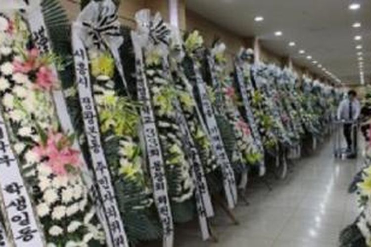 Deretan karangan bunga memenuhi lorong menuju ruang persemayaman bagi Park Jee Young di Incheon, Korea Selatan, Senin (21/4/2014). Park Jee Young adalah satu-satunya kru feri Sewol, kapal yang tenggelam di Korea Selatan pada Rabu (16/4/2014), yang disebut oleh para korban selamat sebagai pahlawan. Dia menjadi satu dari 87 orang yang tewas, hingga Senin. Dalam musibah ini, 215 orang masih hilang, dari total 476 orang di atas kapal ketika kapal tenggelam.