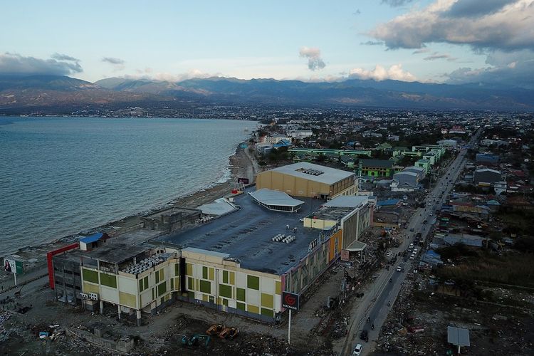 Pengendara melintasi kawasan perbelanjaan dan pertokoan yang rusak akibat tsunami pascagempa di Palu, Sulawesi Tengah, Senin (8/10). Pemerintah mulai membuka akses jalan raya dan membersihkan puing bangunan untuk memulihkan kondisi Kota Palu seusai gempa dan tsunami. 