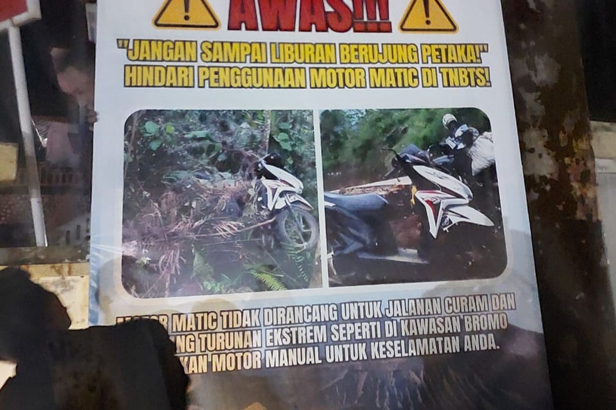 Petugas memasang banner peringatan agar wisatawan Bromo tidak menggunakan motor matic. 