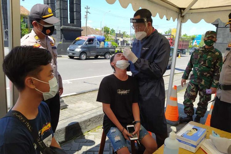 Seorang pengendara kendaraan bermotor dari luar daerah Jawa Tengah menjalani tes antigen Covid-19 di perbatasan Jawa Tengah-Yogyakarta, tepatnya di Salam, Kecamatan Salam, Kabupaten Magelang, Selasa (20/4/2021).