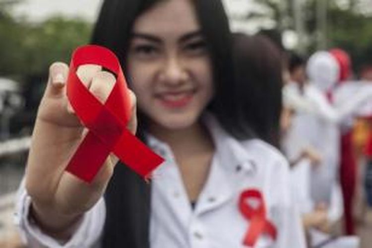 Aktivis membawa pita merah dalam kampanye Hari AIDS Sedunia, di Surabaya, Senin (1/12/2014). Sekitar 45.000 kasus HIV/AIDS terjadi di Indonesia sepanjang 2013 dan 14.400 kematian di tahun yang sama.