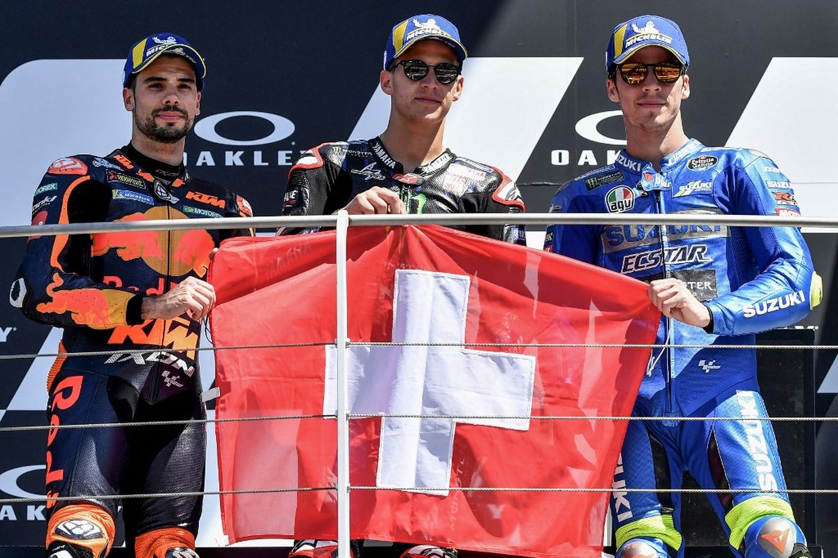 Para pebalap pengisi podium pada MotoGP Italia 2021, yakni Fabio Quartararo, Miguel Oliveira, dan Joan Mir. (Photo by Tiziana FABI / AFP)