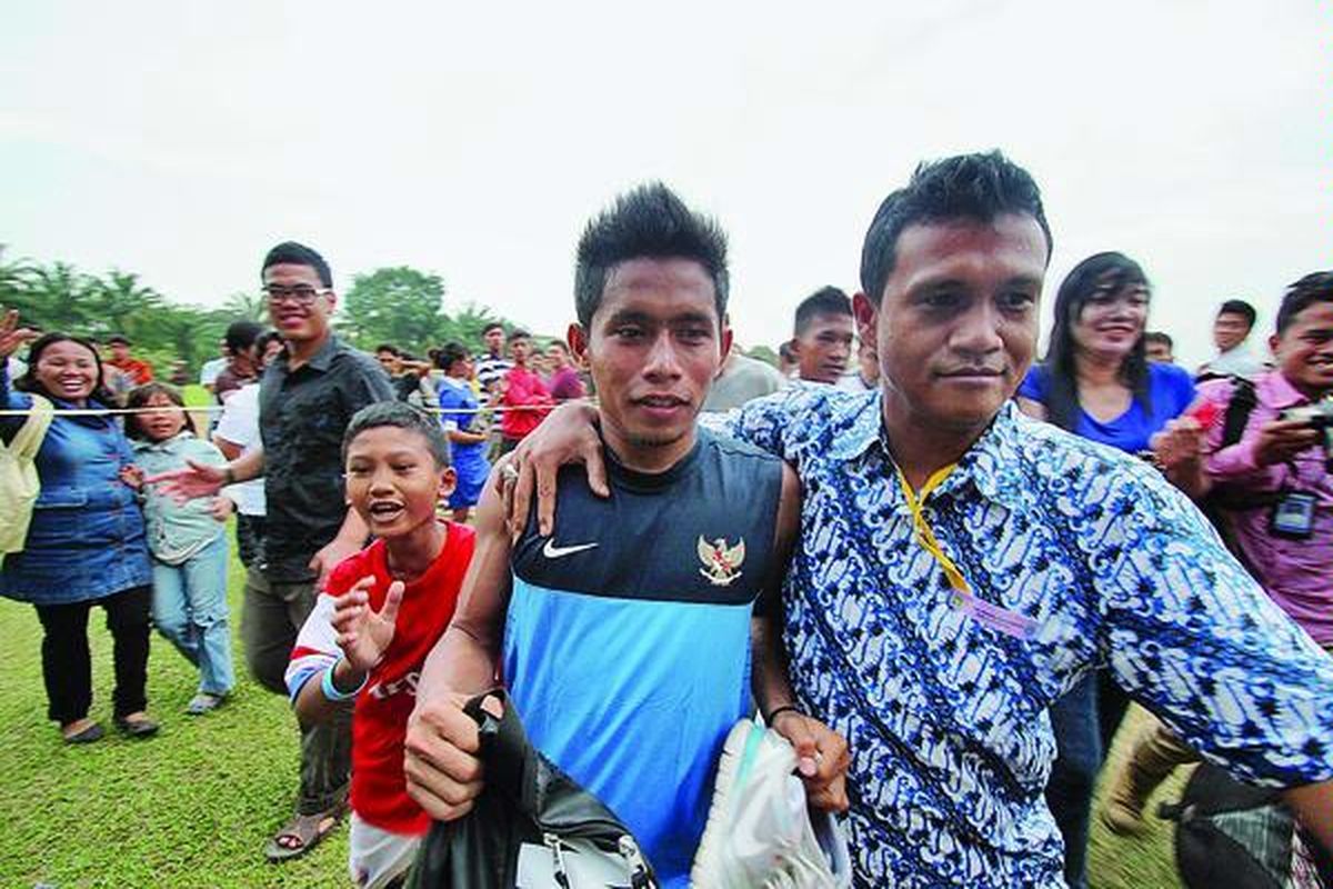 Pesepak bola asal Persebaya Surabaya, Andik Vermansah, dikerumuni penggemarnya seusai latihan tim nasional di Stadion Universitas Sumatera Utara, Medan, Sumut, Senin (14/1). Dua pesepak bola nasional, Andik Vermansah dan Oktovianus Maniani, akhirnya bergabung dengan tim nasional di Medan dalam rangka pelatihan menghadapi kualifikasi Piala Asia 2015.