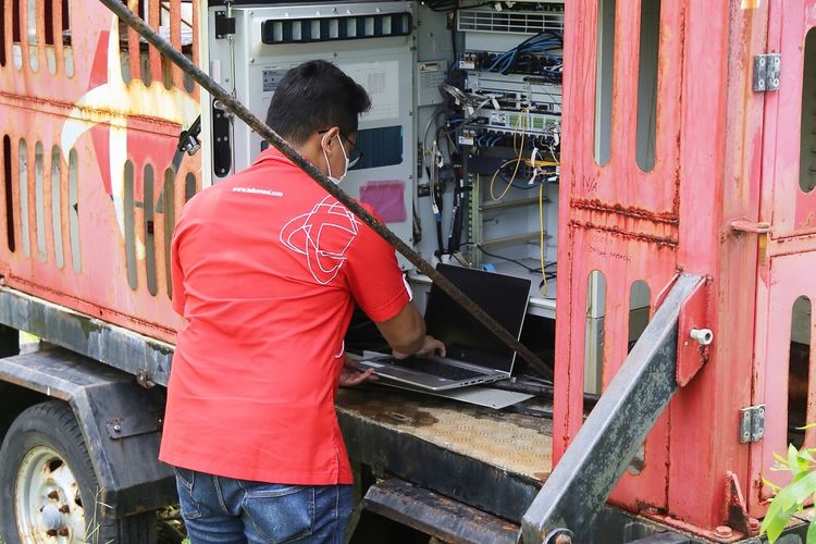 Pekerja memasang peralatan BTS Mobile Telkomsel di Nusa Dua, Bali.