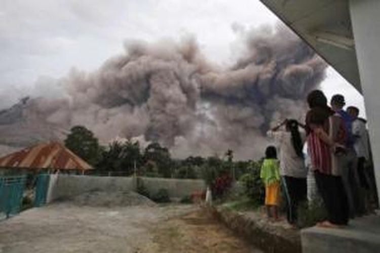 Warga melihat luncuran awan panas Gunung Sinabung dari Desa Tiga Serangkai, Karo, Sumut, 13 Juni 2015. Gunung Sinabung yang kini masih berstatus Awas masih mengalami peningkatan aktivitas.