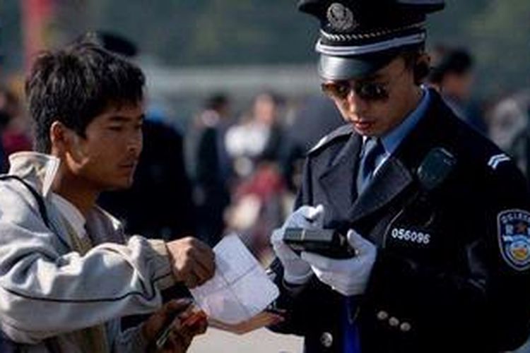 Polisi memeriksa surat-surat yang dibawa seorang pria di Lapangan Tiananmen di Beijing, Kamis (1/11/2012). Penjagaan dan pengamanan ketat diberlakukan menjelang pelaksanaan Kongres Partai Komunis China pada 8 November mendatang. 
