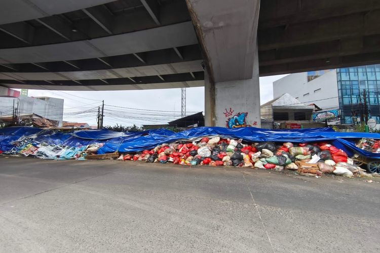 Kondisi sampah di Kolong Flyover Ciputat, masih ditutupi terpal tetapi sebagian sisinya mulai terbuka, Selasa (16/12/2025).