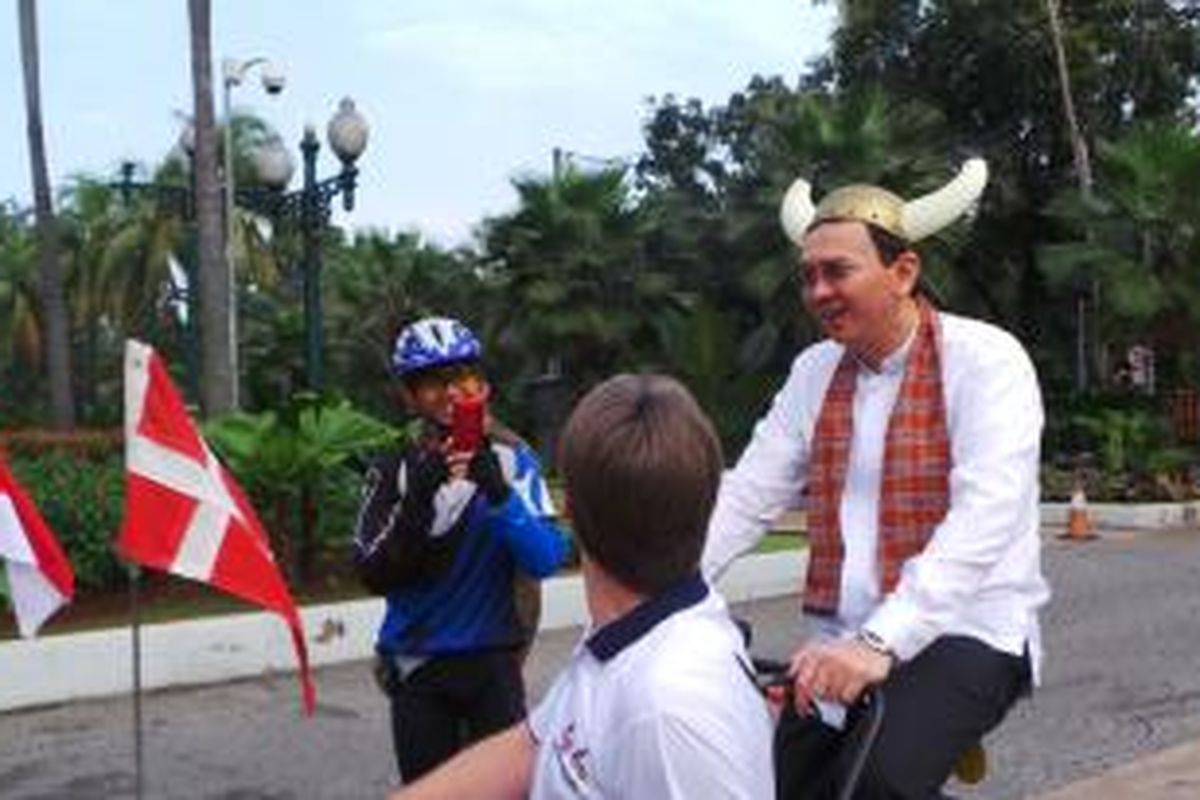 Gubernur DKI Jakarta Basuki Tjahaja Purnama mengayuh sepeda roda tiga dengan gerobak khas Denmark, di halaman Balai Kota, Jumat (20/3/2015). 