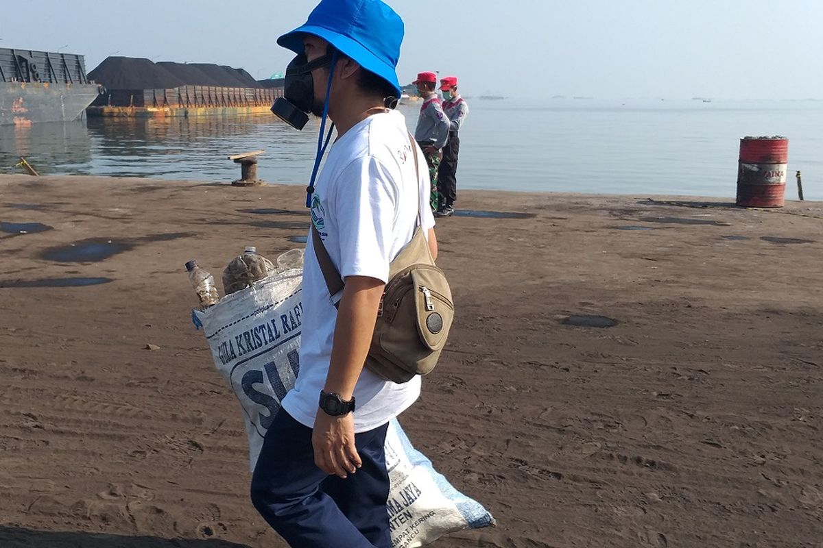 Seorang peserta Bersih Laut dan Pantai membawa karung berisi sampah yang dikumpulkan dari kawasan Pelabuhan Karya Citra Nusantara (KCN) Marunda, Jakarta Utara, Kamis (12/9/2019).
