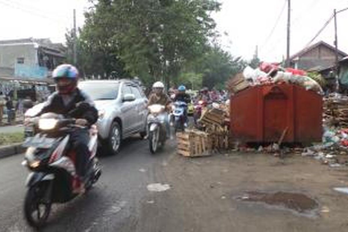 Jalan KRT Radjiman di depan Pasar Pulo Jahe, Kelurahan Rawa Teratai, Kecamatan Cakung, Jakarta Timur menjadi tersendat akibat tumpukan sampah yang diletakan hampir menutupi separuh jalan. Senin (16/6/2014).