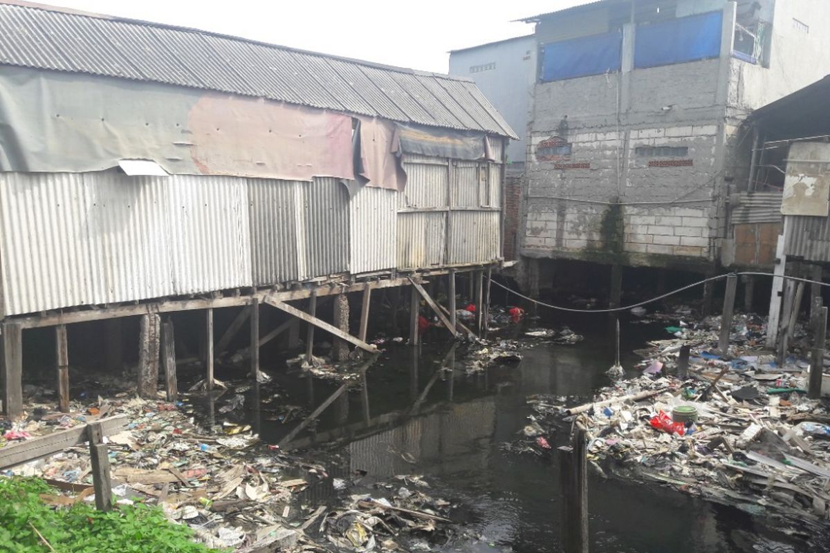 Sejumlah rumah warga berdiri di atas kali yang dipenuhi sampah di RW 17, Penjaringan, Jakarta Utara, Selasa (13/2/2018)