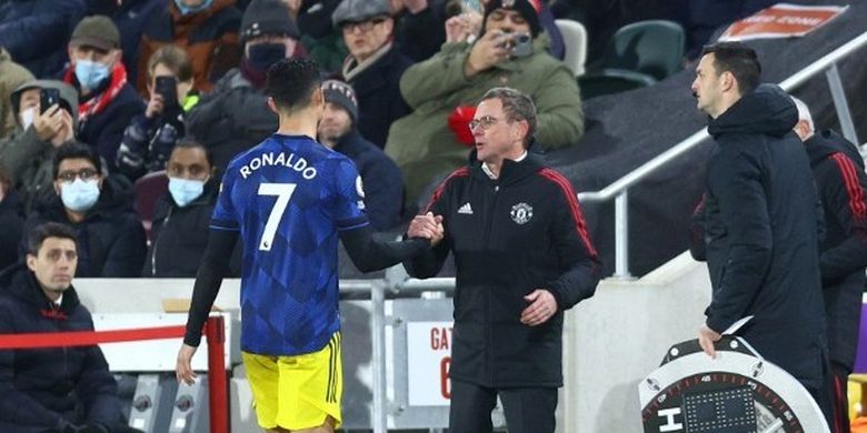 Manajer Manchester United, Ralf Rangnick, berjabat tangan dengan Cristiano Ronaldo saat bintang asal Portugal tersebut menuju bangku cadangan dalam pertandingan Premier League antara Brentford vs Manchester United di Community Stadium, Rabu (19/1/2022).