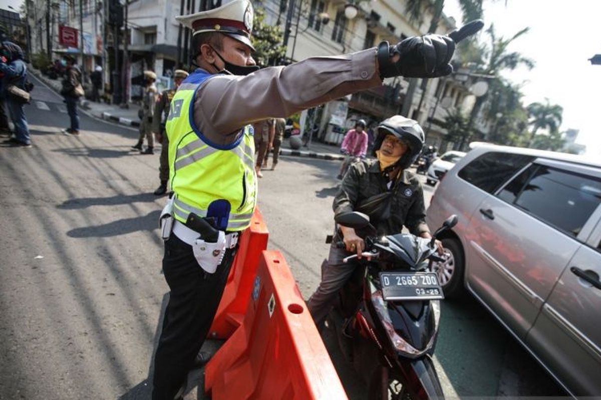 Petugas melakukan penyekatan ganjil genap di Kota Bandung, Jawa Barat. 