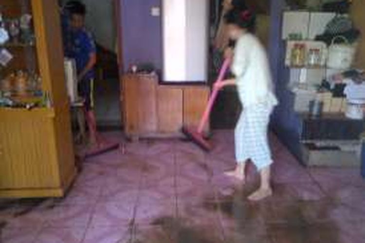 Warga membersihkan lantai setelah rumahnya terendam di Kampung Selaeurih, Dayeuhluhur, Warudoyong, Kota Sukabumi, Jawa Barta, Selasa (8/3/2016) 