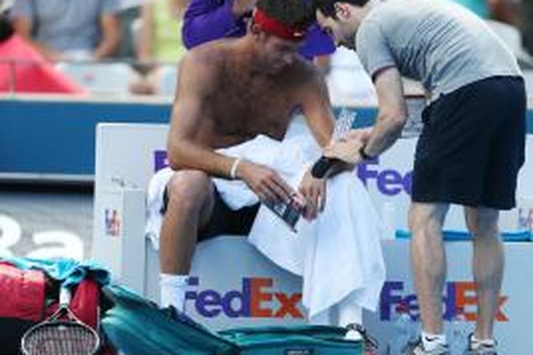 Petenis Argentina, Juan Martin del Potro, mendapatkan perawatan pada tangan kiri saat bertanding melawan petenis Italia, Fabio Fognini, pada babak kedua Sydney International, Rabu (14/1/2015).