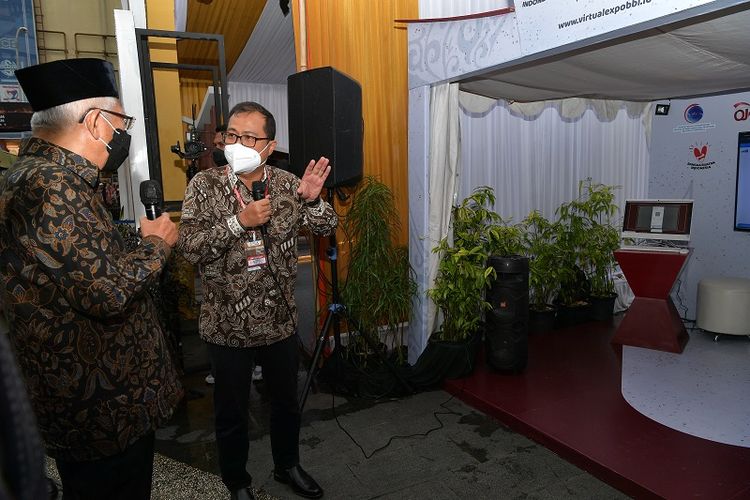 Direktur Strategic Portfolio Telkom Budi Setyawan Wijaya (kanan) menyampaikan penjelasan mengenai Virtual Expo Bangga Buatan Indonesia yang dikembangkan oleh Telkom kepada Wakil Presiden RI K.H. Ma?ruf Amin yang ditampilkan pada booth milik Telkom, Selasa (12/4/2022).