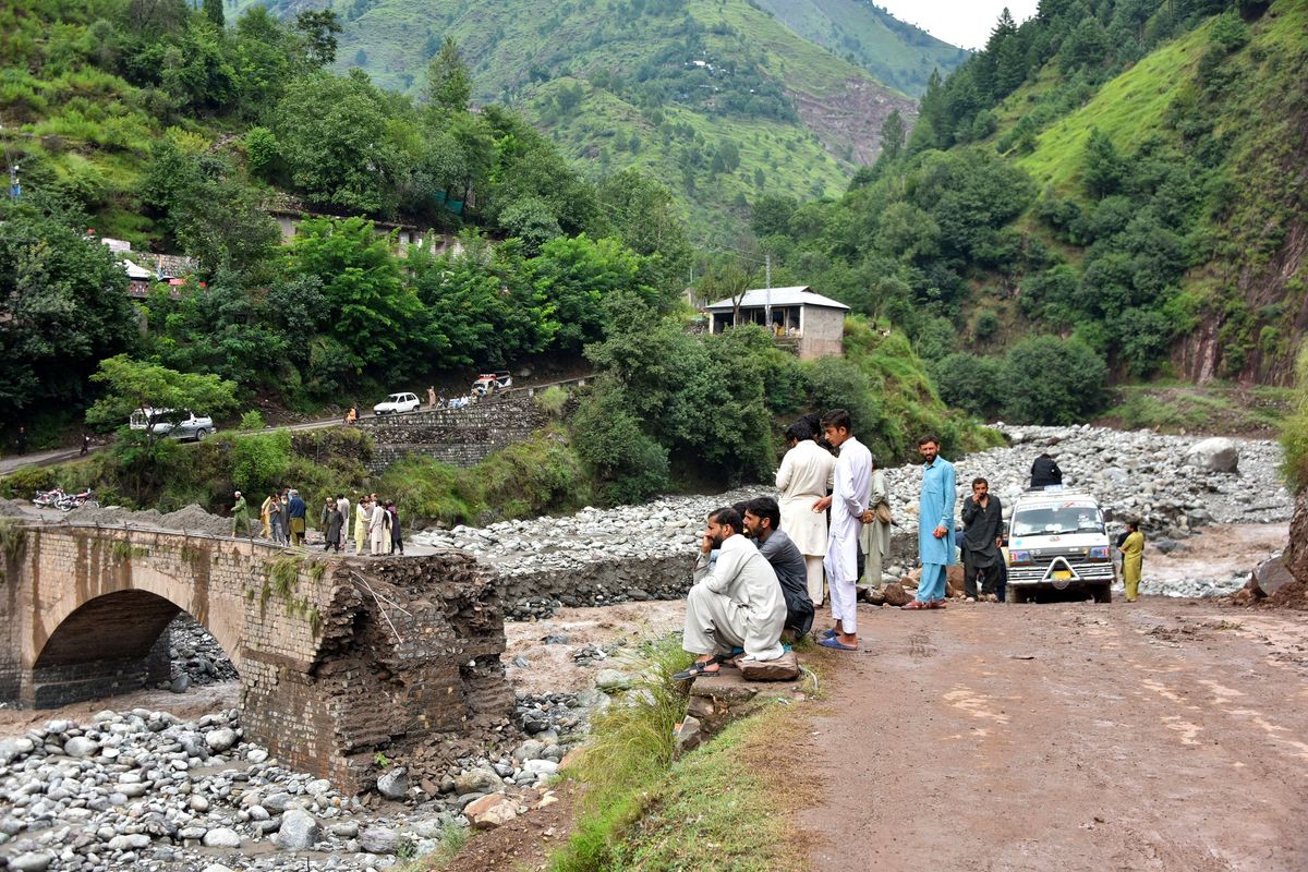 Warga Pakistan duduk-duduk memandangi jembatan yang hancur akibat banjir bandang di pinggiran Muzaffarabad, ibu kota Kashmir wilayah Pakistan, Jumat (15/8/2025).