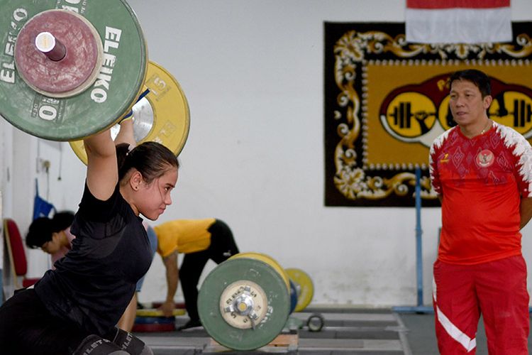 Lifter putri Indonesia Putri Aulia Andriani (kiri) berlatih disaksikan pelatih angkat besi, Dirja Wihardja (kanan) disela-sela pemusatan latihan nasional (Pelatnas) di Mess Kwini, Jakarta, Selasa (10/9/2019). Pengurus Besar Persatuan Angkat Berat, Binaraga, Angkat Besi Seluruh Indonesia (PB PABBSI) menargetkan juara umum pada perhelatan SEA Games 2019 di Manila, FIlipina.