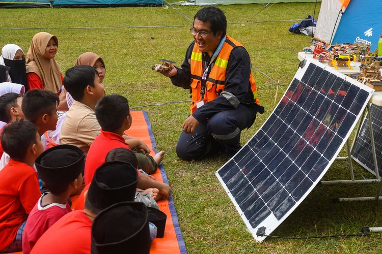 Pengguna PLTS atap off grid yang juga aktivis energi terbarukan Hafiz Riza memberikan penjelasan tentang panel surya kepada anak-anak peserta acara Camping Kemerdekaan di kawasan perkemahan Batu Kembar, Caringin, Kabupaten Bogor, Jawa Barat, Sabtu (19/8/2023). 