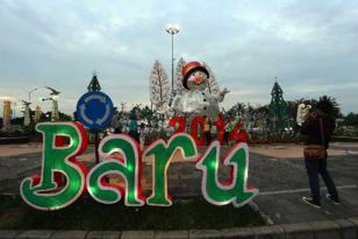 Pengunjung berfoto di ornamen Natal dan Tahun Baru 2014 yang dipajang di Bunderan Taman Impian Jaya Ancol, Jakarta Utara, Selasa (24/12/2013). Menjelang perayaan Tahun baru 2014, sejumlah tempat wisata memajang ornamen dan mengadakan berbagai program acara.  