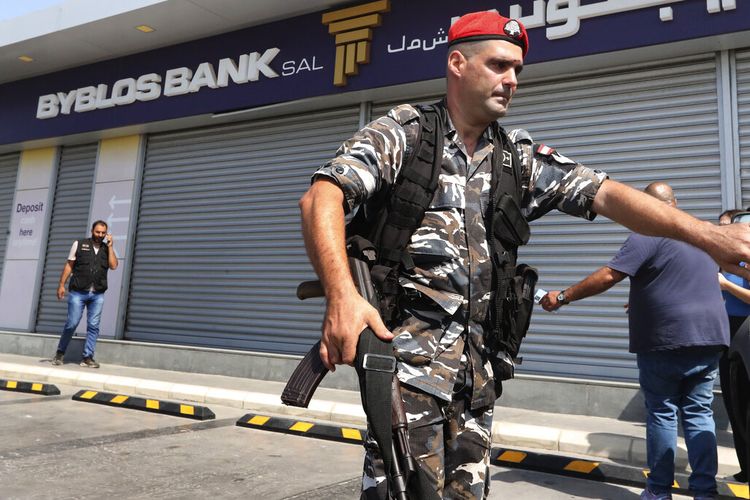 Petugas keamanan Lebanon berdiri di luar cabang Bank Byblos yang dibobol oleh deposan Ali Hodroj memegang pistol, melepaskan tembakan peringatan dan menuntut sekitar $40.000 dari tabungannya yang terperangkap, di Tyre, Lebanon selatan, Selasa, 4 Oktober 2022. 