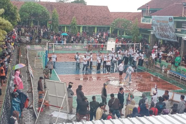 Warga berkerumun menyaksikan pertandingan voli sebelum akhirnya dibubarkan petugas keamanan dalam turnamen yang digelar di sebuah sekolah di Desa Kretek, Kecamatan Paguyangan Kabupaten Brebes, Jawa Tengah, Minggu (27/9/2020)