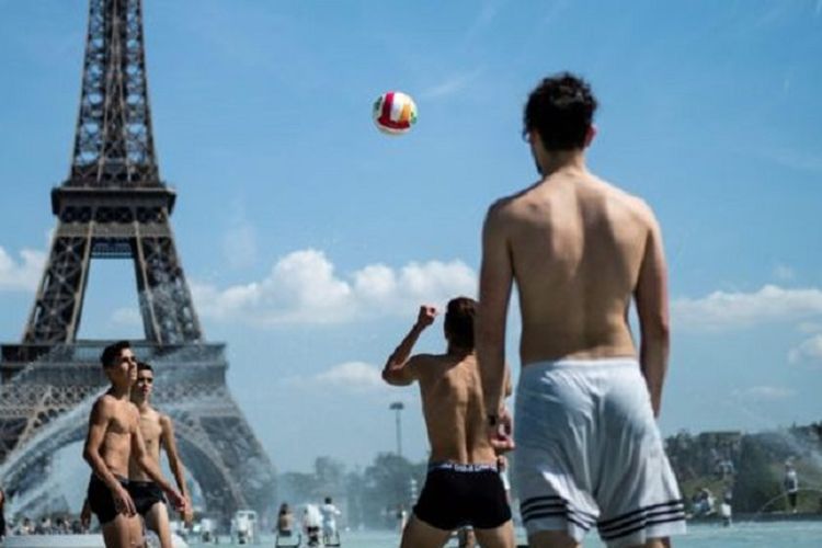Sekelompok pemuda bermain voli di sebuah kolam air mancur di Paris, Perancis.