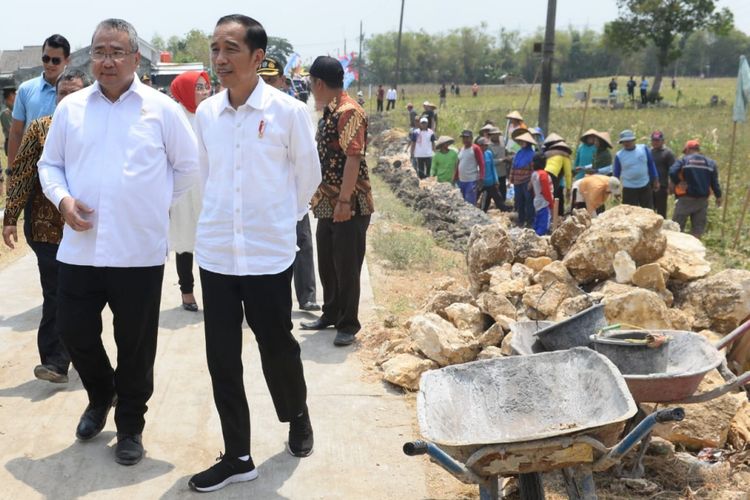 Presiden Joko Widodo (Jokowi) didampingi Menteri Desa, Pembangunan Daerah Tertinggal, dan Transmigrasi (Mendes PDTT) Eko Putro Sandjojo meninjau program Padat Karya Tunai (PKT) pembangunan talud jalan di Desa Tambirejo, Kecamatan Toroh, Kabupaten Grobogan, Jawa Tengah, Sabtu (15/9/2018)