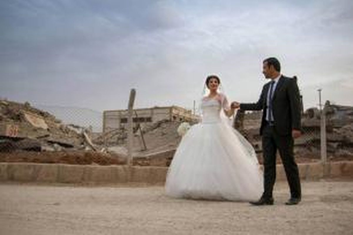 Pasangan pengantin yang berasal dari suku Kurdi begitu berani melangsungkan pernikahan di area bekas peperangan di Suriah. 