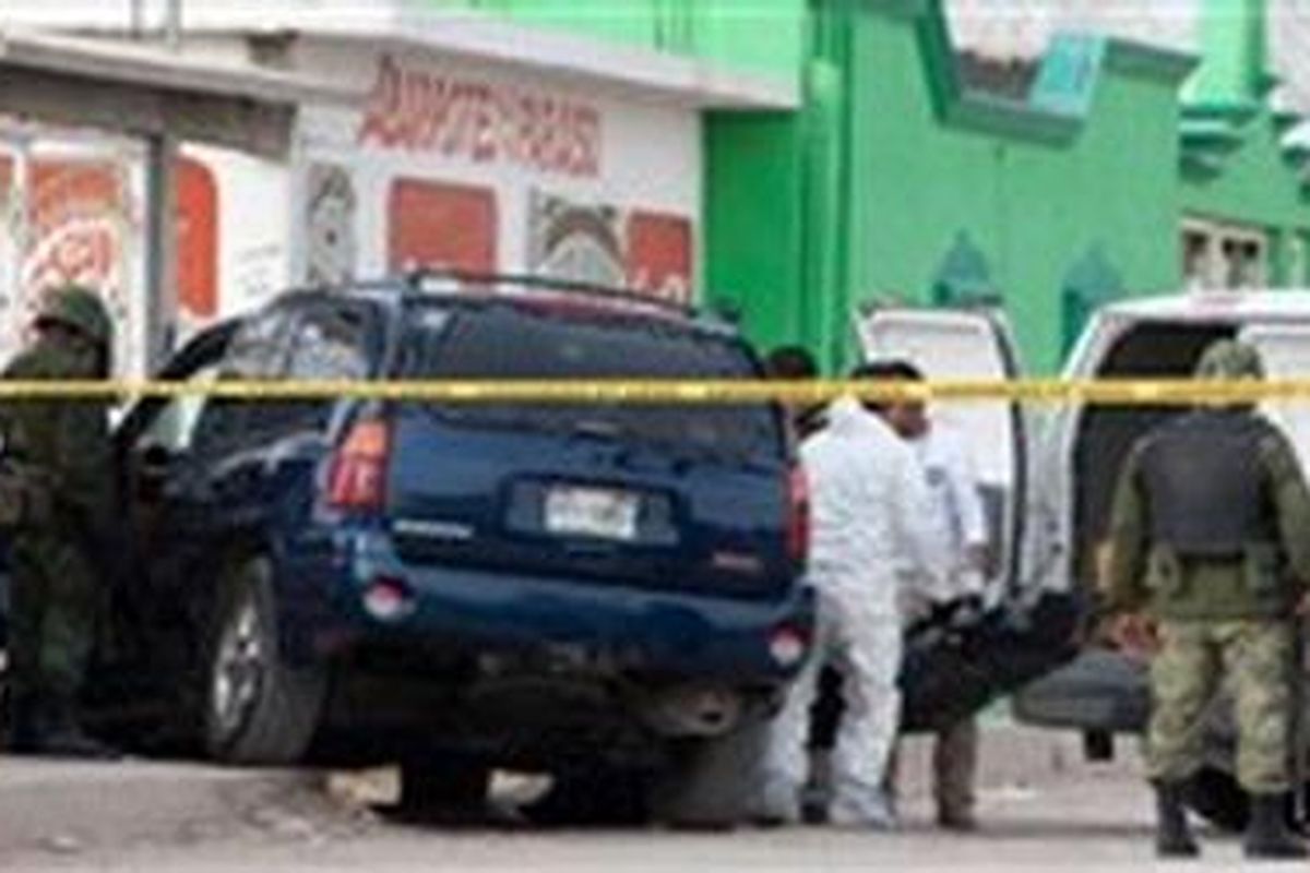 Anggota tim forensik Meksiko membawa mayat seorang pria yang tergeletak di van di Internacional Avenue di Ciudad Juarez, Meksiko setelah diserang oleh kelompok yang diduga geng narkoba 