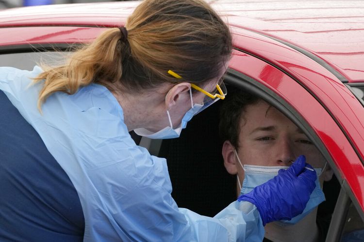 Seorang pria menjalani swab di klinik pengujian Covid-19 drive-through di Pantai Bondi di Sydney, Selasa, 21 Desember 2021. 